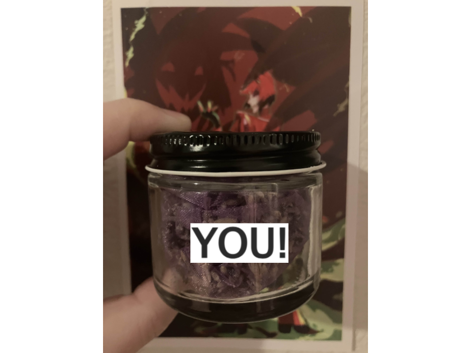 A picture of a small jar with a pouch of lavender inside it held over a print of Alastor. The text "<strong>YOU!</strong>" is over the lavender.
